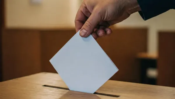 mano che inserisce una scheda elettorale in una urna. immagine AI generated